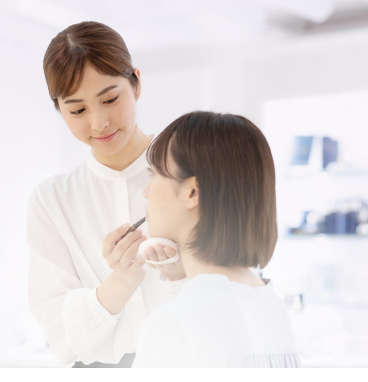 お客様にメイクするスタッフ