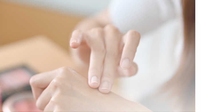 ハンドクリームを塗る手