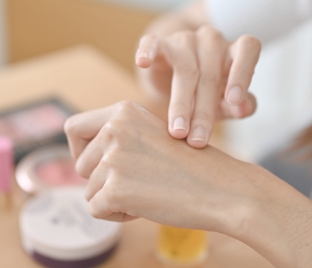 ハンドクリームを塗る手